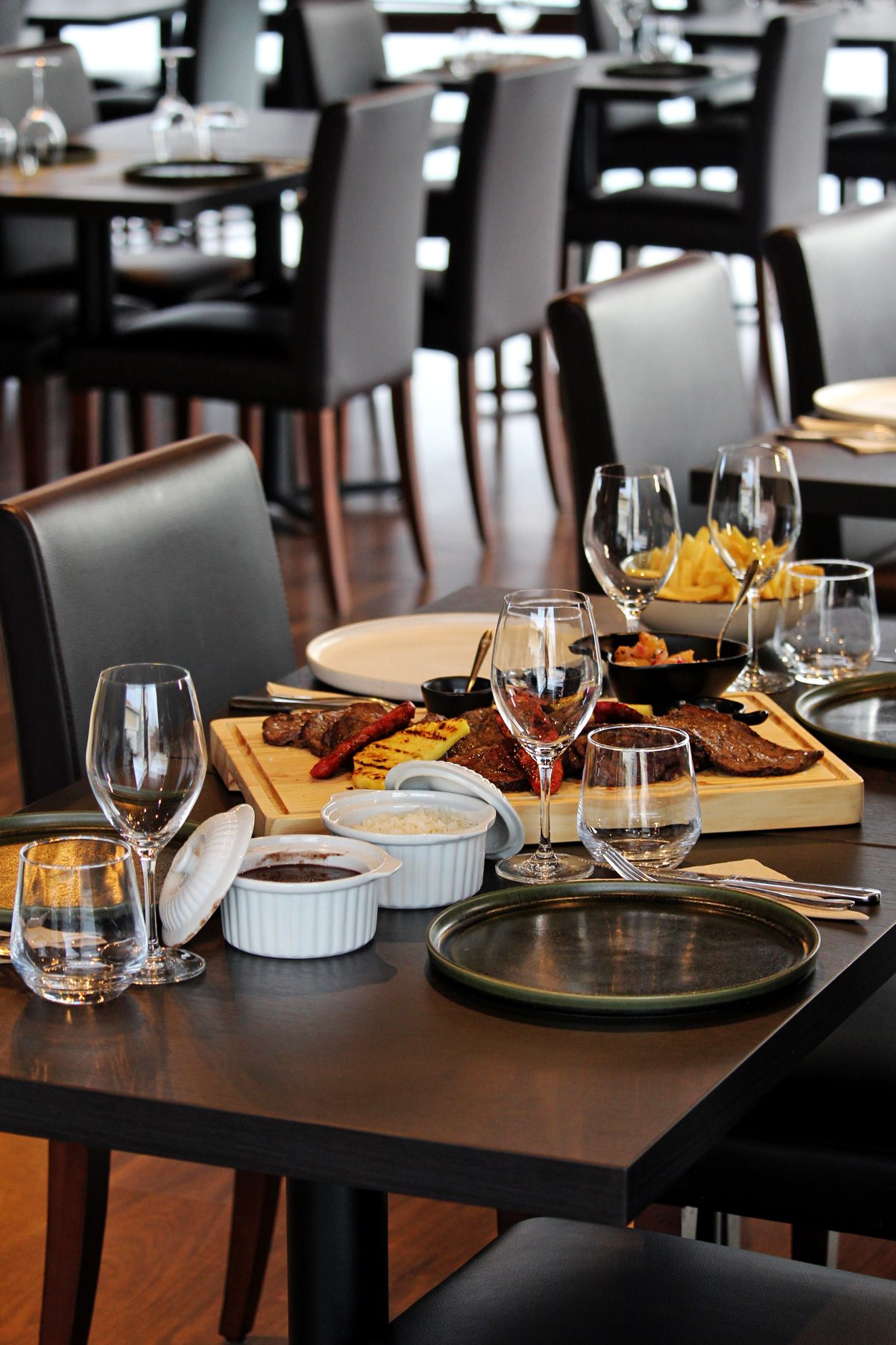Mesa posta com tábua de carnes e acompanhamentos